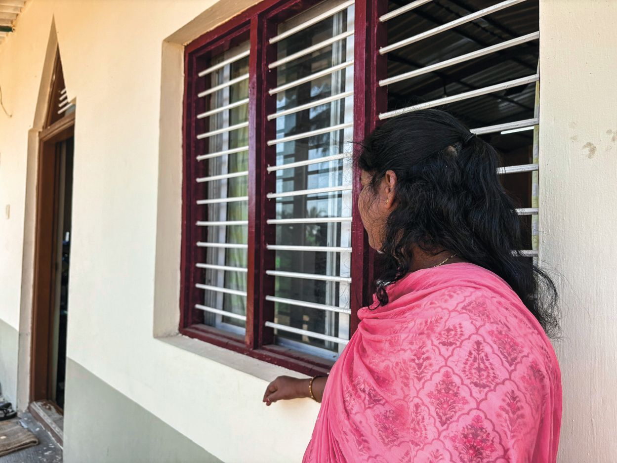 Ženska gleda skozi okno.