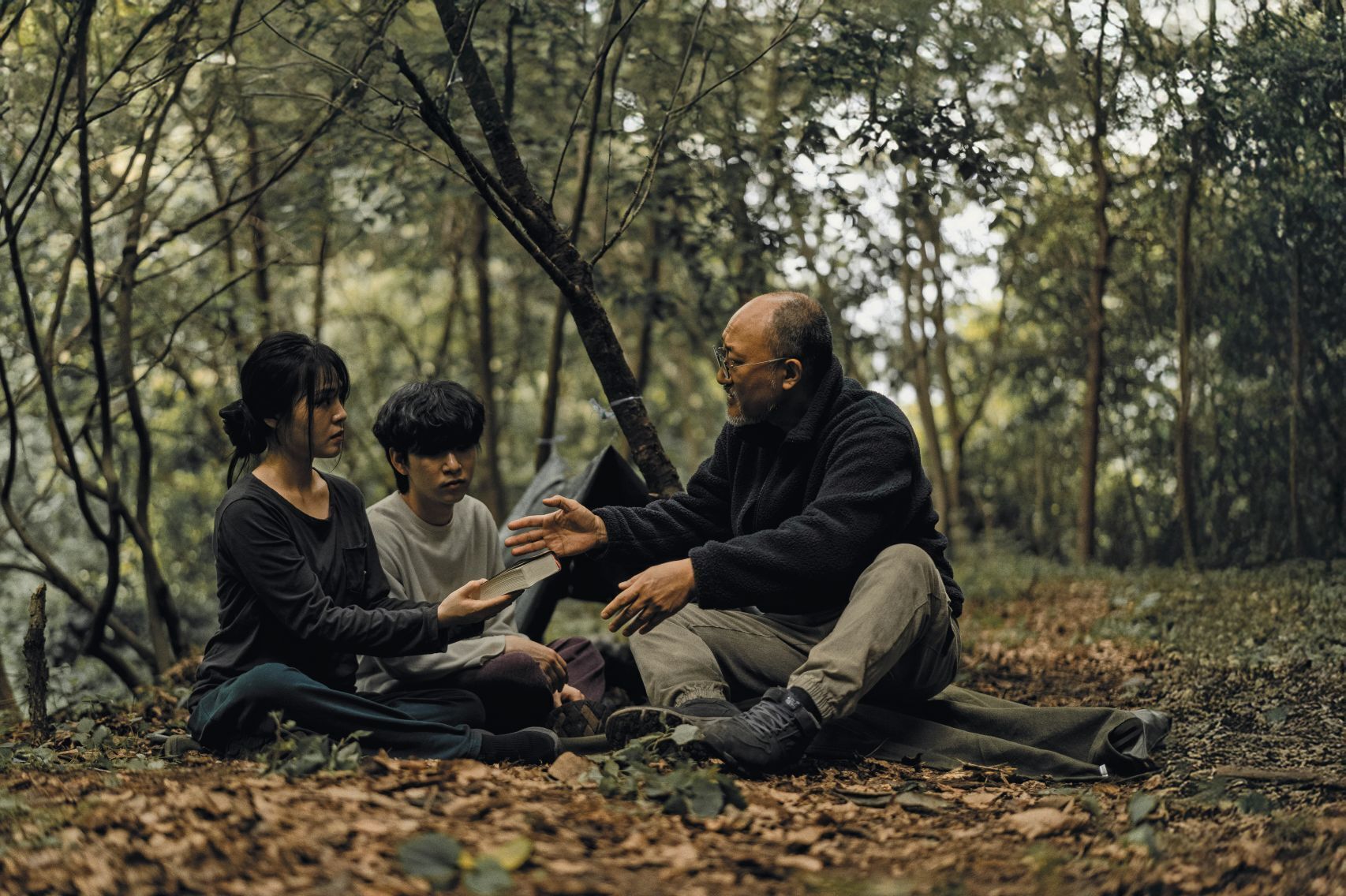 Mladi poslušajo evangelista v gozdu. Ilustracija, ki prikazuje skrivno srečanje preganjanih kristjanov.